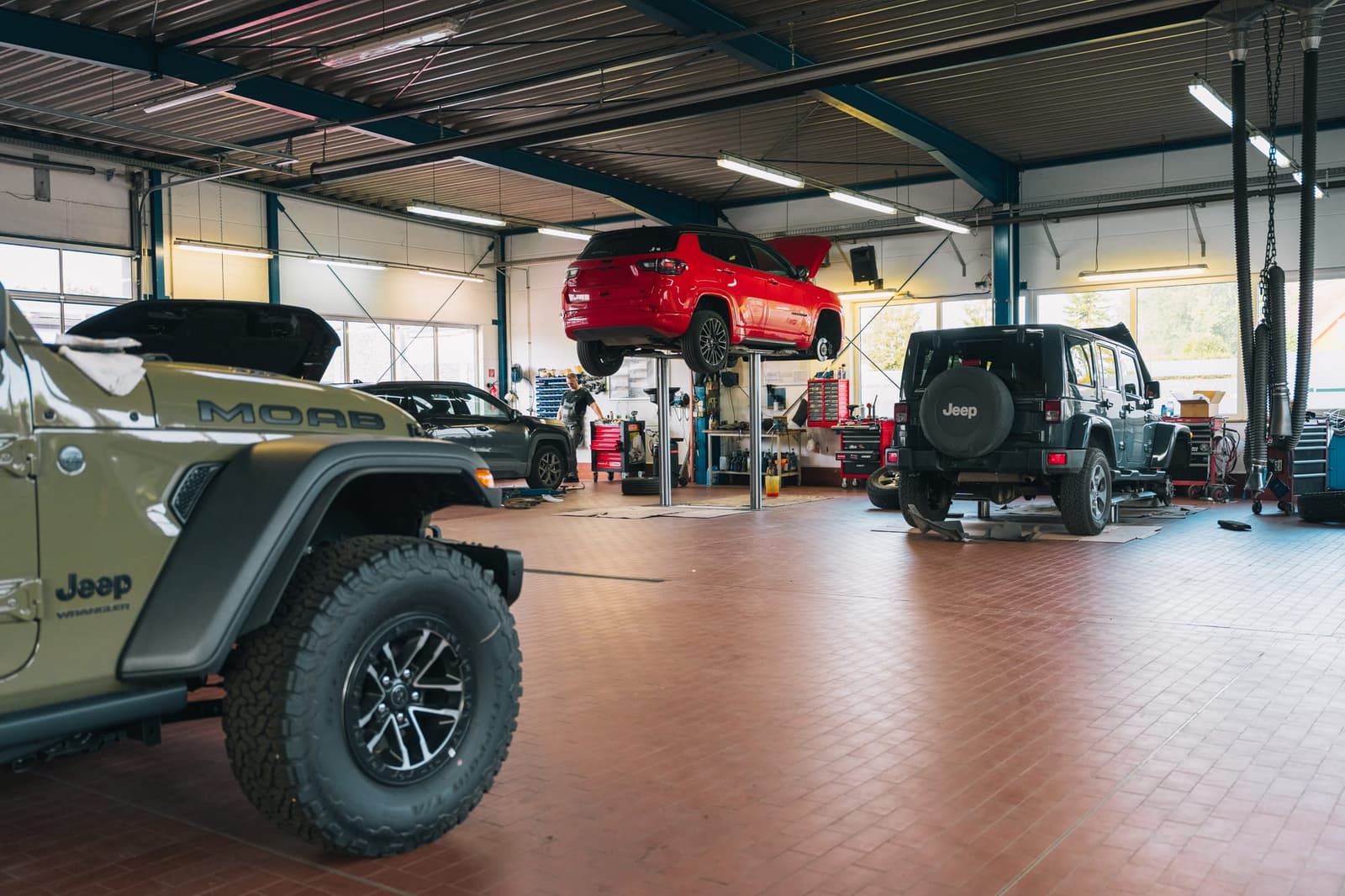 Werkstatthalle von Autohaus Fritz: vorn ein Jeep, dahinter Fahrzeuge auf Hebebühnen